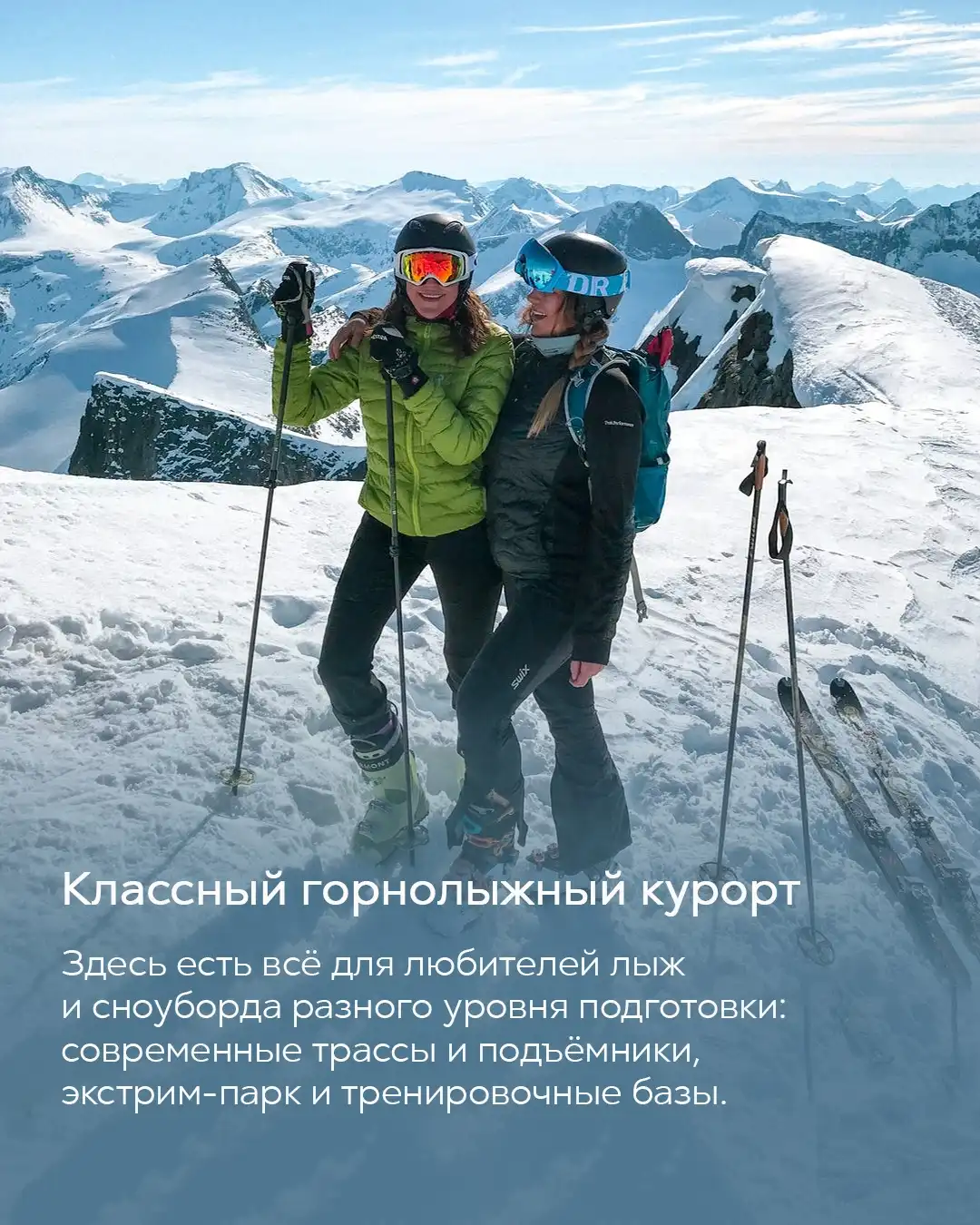 Две девушки на лыжном курорте в шлемах и очках позируют на вершине заснеженной горы Красной Поляны
