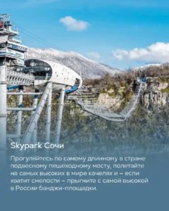 Подвесной пешеходный мост и канатный спуск Skypark Сочи над ущельем на фоне зимних гор