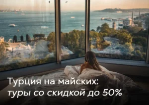 Девушка отдыхает в кровати у панорамного окна с видом на пролив Босфор и мечеть в Стамбуле, Турция. Туры в Турцию на майские со скидкой до 50%